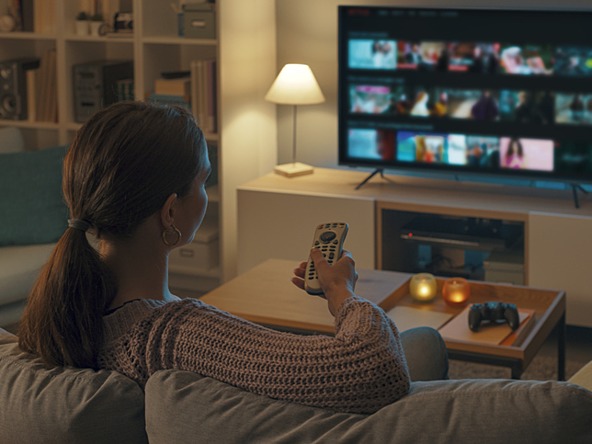 Woman sitting on couch watching TV media audience viewing television dec 25_crop